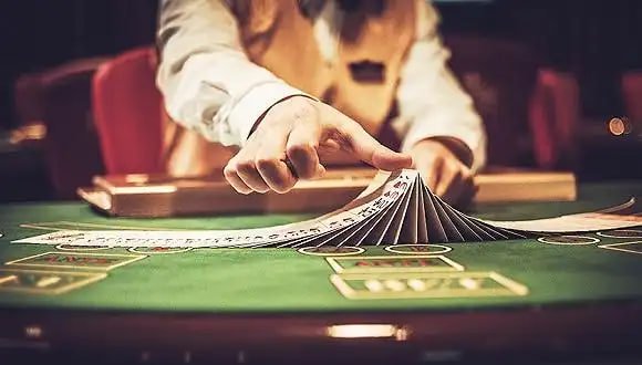 queenbet live casino dealer table with baccarat cards in Philippines